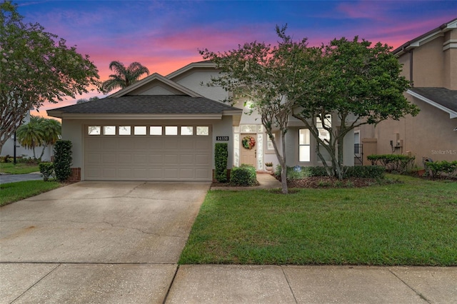 14558 Mandolin Dr, Orlando, FL 32837 - view of front facade with stucco siding, a lawn, concrete driveway, and an attached garage