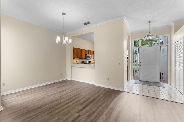 14558 Mandolin Dr, Orlando, FL 32837 - foyer with wood finished floors, a chandelier, ornamental molding, and a textured ceiling