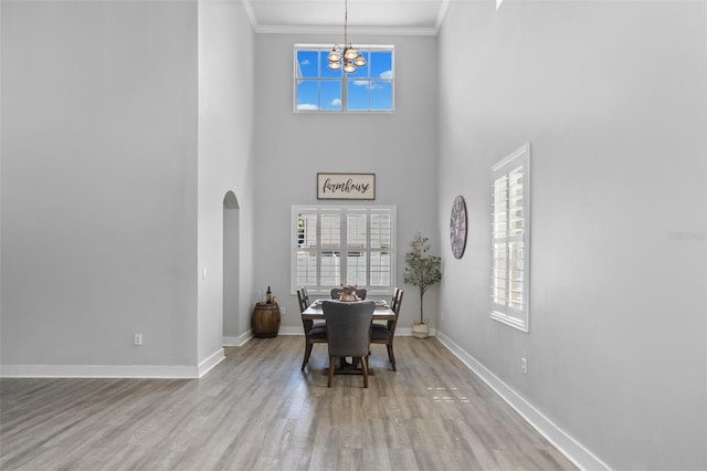 12978 SW 26th St, Miramar, FL 33027 - dining room featuring a chandelier, wood finished floors, healthy amount of natural light, arched walkways, and ornamental molding