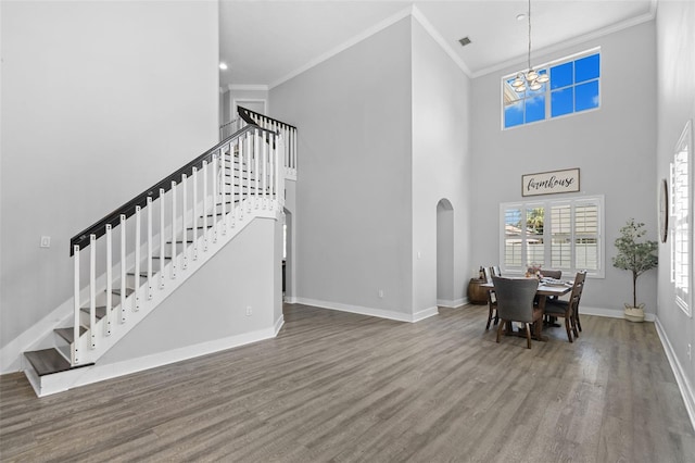 12978 SW 26th St, Miramar, FL 33027 - dining room with stairs, ornamental molding, wood finished floors, arched walkways, and a chandelier