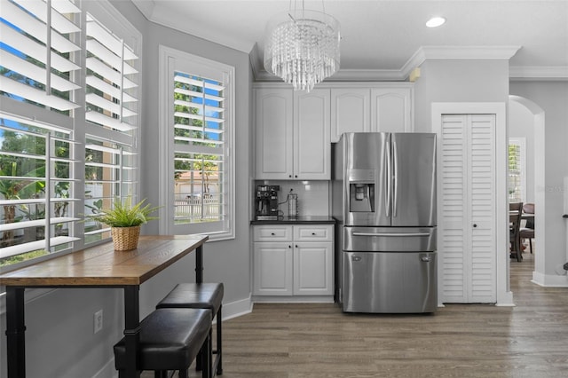 12978 SW 26th St, Miramar, FL 33027 - kitchen featuring stainless steel fridge with ice dispenser, crown molding, arched walkways, wood finished floors, and a chandelier