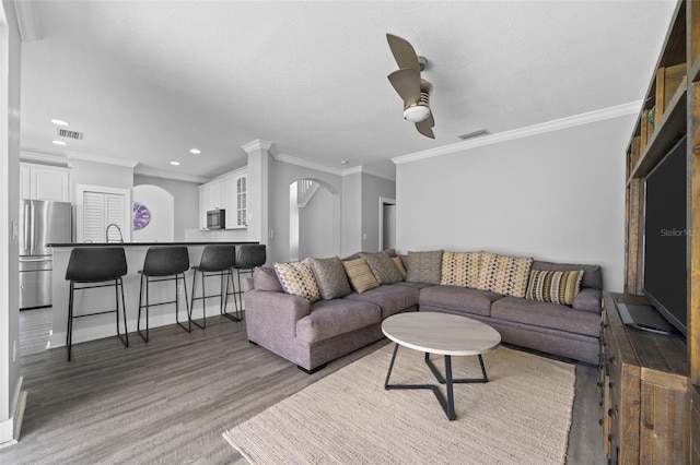 12978 SW 26th St, Miramar, FL 33027 - living room with arched walkways, ceiling fan, crown molding, recessed lighting, and wood finished floors