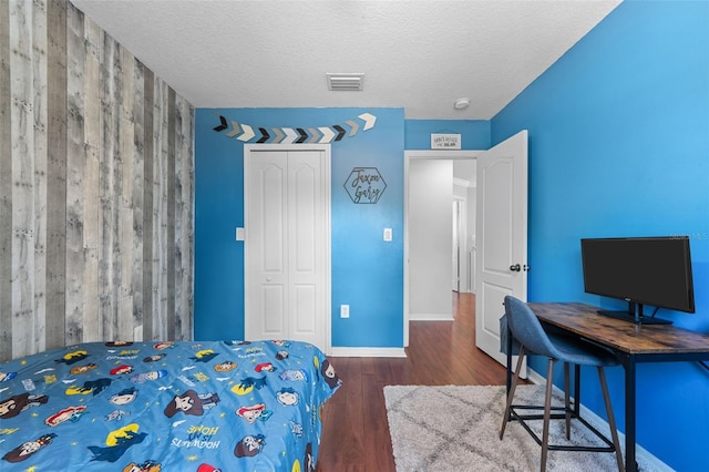 12978 SW 26th St, Miramar, FL 33027 - bedroom with an accent wall, wood finished floors, a closet, and a textured ceiling