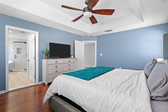 12978 SW 26th St, Miramar, FL 33027 - bedroom featuring a raised ceiling, dark wood-style flooring, ceiling fan, and connected bathroom