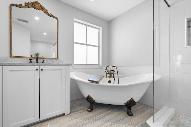 12978 SW 26th St, Miramar, FL 33027 - full bathroom with vanity, a freestanding tub, tile walls, tiled shower, and a wainscoted wall