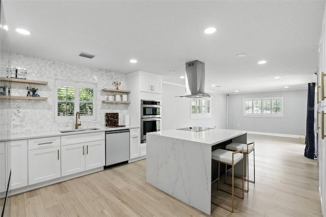 4611 Cranston Pl, Orlando, FL 32812 - kitchen with island range hood, stainless steel appliances, open shelves, a kitchen island, and white cabinets