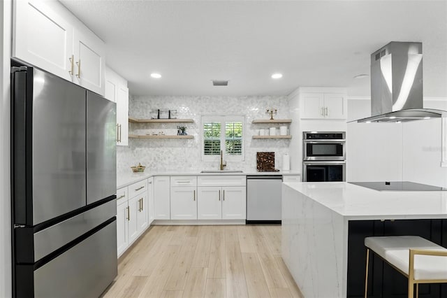 4611 Cranston Pl, Orlando, FL 32812 - kitchen featuring appliances with stainless steel finishes, island exhaust hood, open shelves, light wood finished floors, and recessed lighting