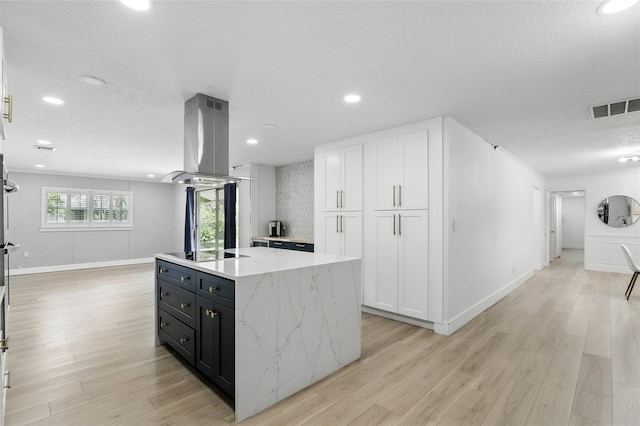 4611 Cranston Pl, Orlando, FL 32812 - kitchen featuring island exhaust hood, black electric stovetop, white cabinets, a center island, and recessed lighting