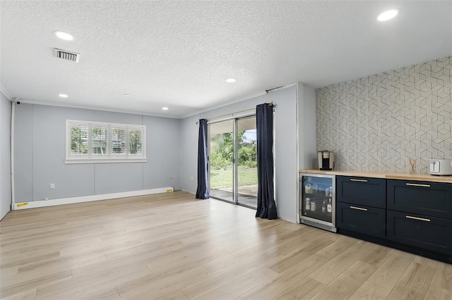 4611 Cranston Pl, Orlando, FL 32812 - indoor bar featuring beverage cooler, light wood finished floors, a textured ceiling, recessed lighting, and an accent wall