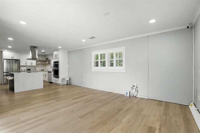 4611 Cranston Pl, Orlando, FL 32812 - unfurnished living room with crown molding, light wood-type flooring, recessed lighting, and a textured ceiling