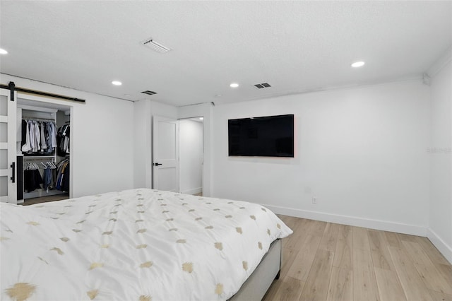 4611 Cranston Pl, Orlando, FL 32812 - bedroom featuring recessed lighting, light wood-style flooring, and a barn door