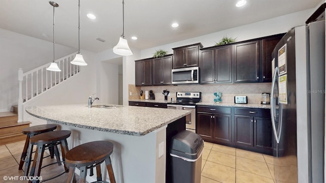 8806 Geneve Ct, Kissimmee, FL 34747 - kitchen featuring stainless steel appliances, light tile patterned flooring, backsplash, a kitchen breakfast bar, and dark brown cabinets