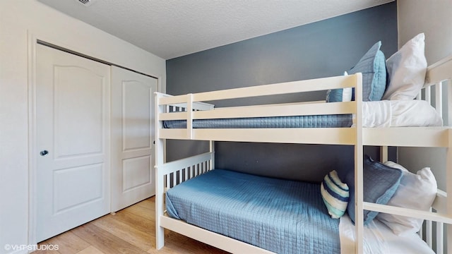 8806 Geneve Ct, Kissimmee, FL 34747 - bedroom featuring wood finished floors, a textured ceiling, and a closet