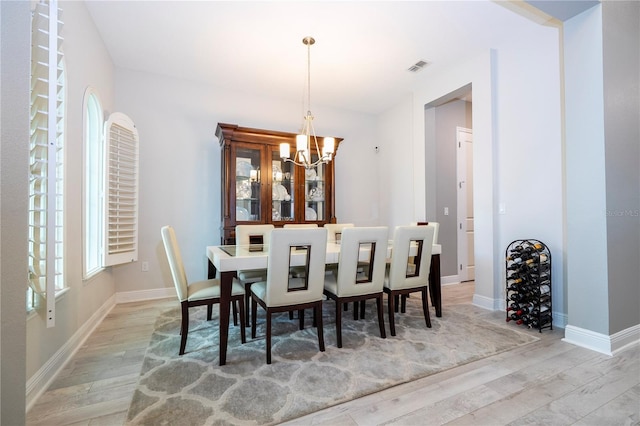 8066 Ludington Cir, Orlando, FL 32836 - dining space with light wood-style floors and a chandelier
