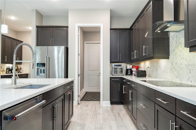 8066 Ludington Cir, Orlando, FL 32836 - kitchen featuring stainless steel appliances, wall chimney range hood, light countertops, dark brown cabinetry, and light wood finished floors