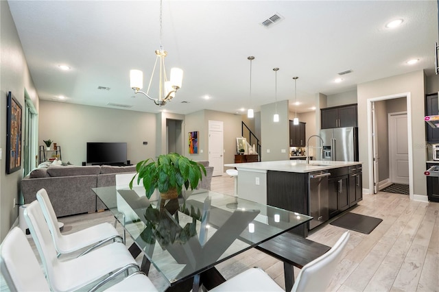 8066 Ludington Cir, Orlando, FL 32836 - dining area with light wood-type flooring, a chandelier, stairs, and recessed lighting