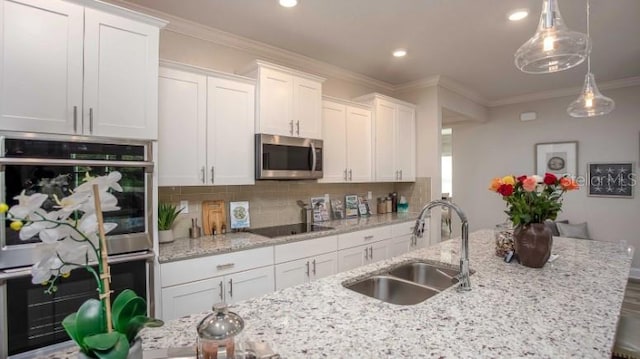 279 SW Cadence Gln, Lake City, FL 32024 - kitchen with appliances with stainless steel finishes, white cabinetry, tasteful backsplash, ornamental molding, and recessed lighting