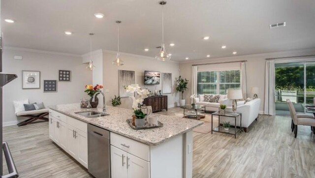 279 SW Cadence Gln, Lake City, FL 32024 - kitchen with open floor plan, dishwasher, crown molding, light wood-type flooring, and white cabinetry
