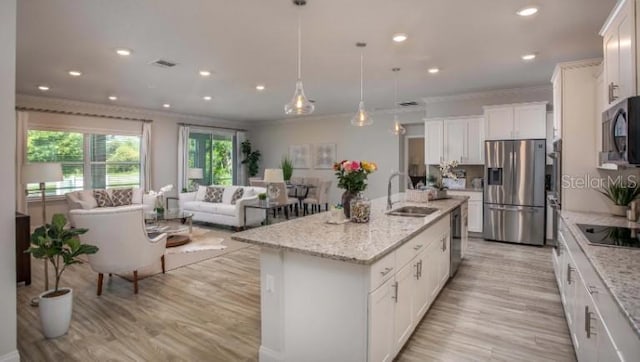 279 SW Cadence Gln, Lake City, FL 32024 - kitchen featuring appliances with stainless steel finishes, ornamental molding, light wood-style floors, white cabinets, and open floor plan