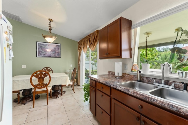 470 Cardinal Ct, Kissimmee, FL 34759 - kitchen with vaulted ceiling, dark countertops, decorative light fixtures, freestanding refrigerator, and light tile patterned floors