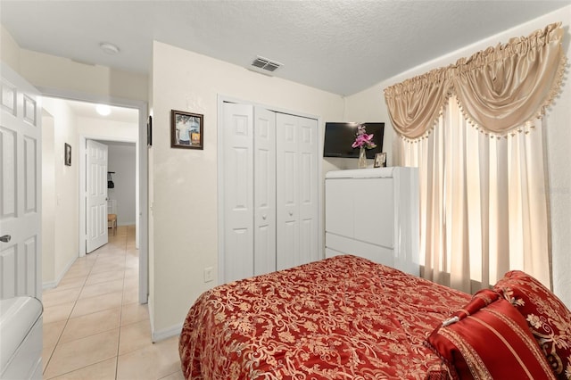 470 Cardinal Ct, Kissimmee, FL 34759 - bedroom with light tile patterned floors, a textured ceiling, and a closet