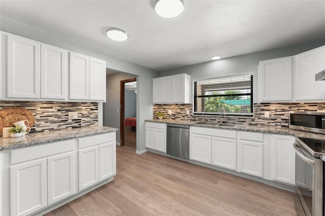 473 Burnt Tree Ln, Apopka, FL 32712 - kitchen featuring stainless steel appliances, backsplash, white cabinets, light wood finished floors, and recessed lighting