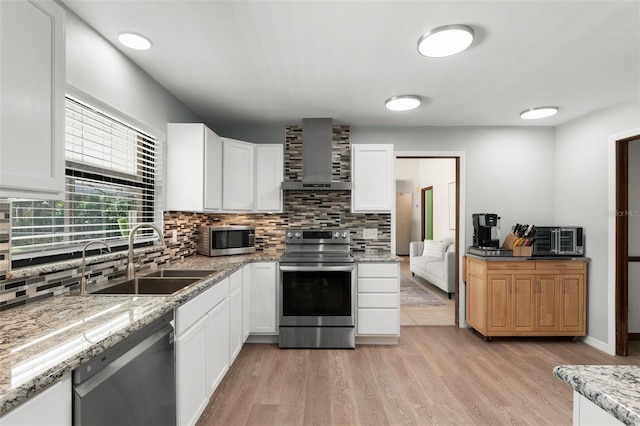 473 Burnt Tree Ln, Apopka, FL 32712 - kitchen featuring stainless steel appliances, wall chimney exhaust hood, decorative backsplash, and light wood finished floors