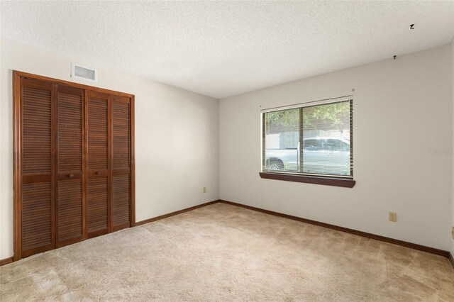 473 Burnt Tree Ln, Apopka, FL 32712 - unfurnished bedroom featuring a closet, light carpet, and a textured ceiling