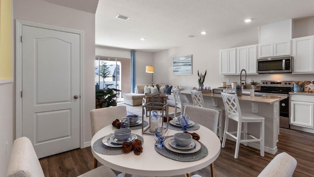 2008 Monteverde Ave, Davenport, FL 33837 - dining room with dark wood finished floors, recessed lighting, and a textured ceiling