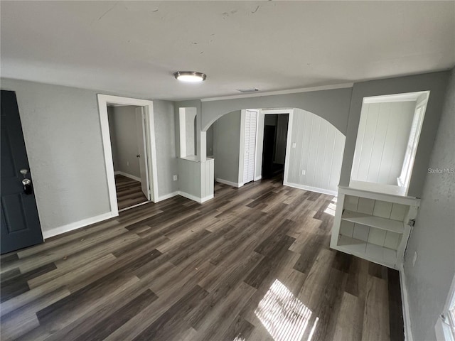 2107 Hollywood Ave, Eustis, FL 32726 - spare room featuring arched walkways and dark wood-style flooring