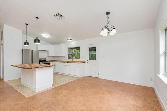 4085 Cypress Bnd, Geneva, FL 32732 - kitchen with appliances with stainless steel finishes, butcher block counters, white cabinets, pendant lighting, and vaulted ceiling