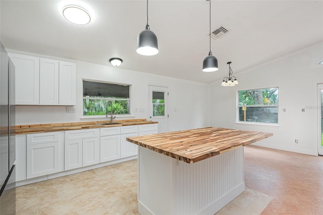 4085 Cypress Bnd, Geneva, FL 32732 - kitchen featuring butcher block countertops, healthy amount of natural light, white cabinetry, and pendant lighting
