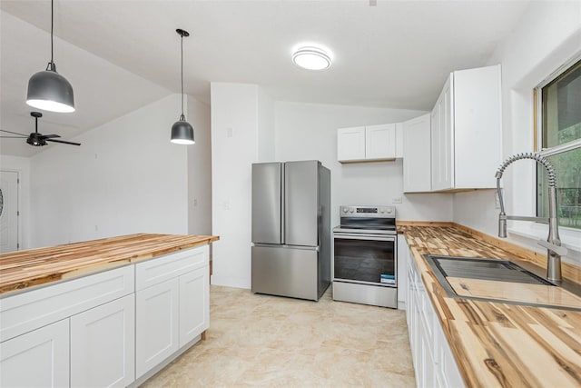 4085 Cypress Bnd, Geneva, FL 32732 - kitchen with butcher block countertops, stainless steel appliances, lofted ceiling, white cabinetry, and hanging light fixtures