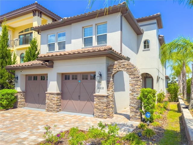 16210 Ravenna Ct, Montverde, FL 34756 - mediterranean / spanish-style home with an attached garage, stucco siding, stone siding, and a tile roof