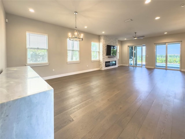 16210 Ravenna Ct, Montverde, FL 34756 - unfurnished living room with a fireplace, dark wood-style flooring, recessed lighting, ceiling fan, and a chandelier