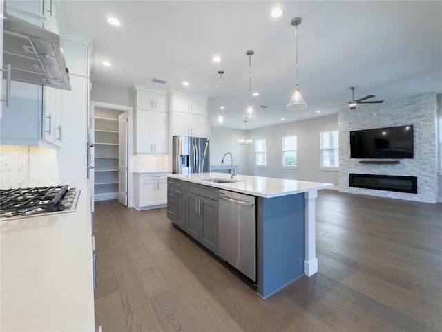 16210 Ravenna Ct, Montverde, FL 34756 - kitchen featuring appliances with stainless steel finishes, extractor fan, ceiling fan, dark wood-style flooring, and open floor plan
