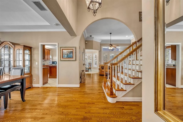 413 Harbour Oaks Pointe Dr, Edgewood, FL 32809 - foyer featuring arched walkways, a ceiling fan, light wood-style flooring, ornamental molding, and stairway