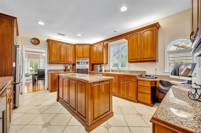 413 Harbour Oaks Pointe Dr, Edgewood, FL 32809 - kitchen with appliances with stainless steel finishes, light countertops, brown cabinets, light tile patterned floors, and recessed lighting