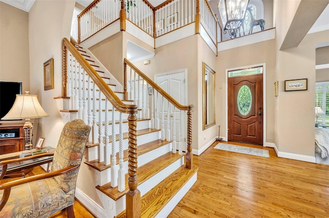 413 Harbour Oaks Pointe Dr, Edgewood, FL 32809 - entrance foyer featuring wood finished floors, a towering ceiling, stairs, and a chandelier