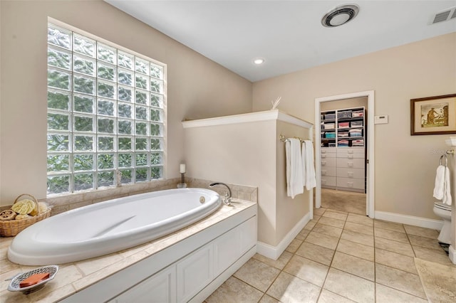 413 Harbour Oaks Pointe Dr, Edgewood, FL 32809 - bathroom with a garden tub, healthy amount of natural light, a walk in closet, and tile patterned floors