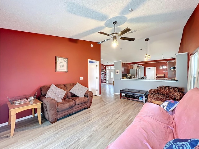 1044 Dees Dr, Oviedo, FL 32765 - living area with a ceiling fan, light wood-type flooring, vaulted ceiling, and a textured ceiling