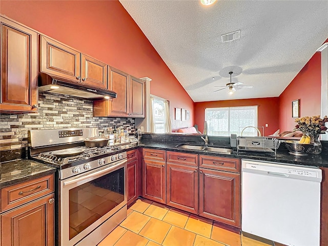 1044 Dees Dr, Oviedo, FL 32765 - kitchen featuring white dishwasher, stainless steel gas range oven, under cabinet range hood, a textured ceiling, and lofted ceiling