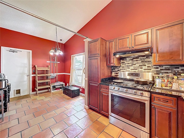 1044 Dees Dr, Oviedo, FL 32765 - kitchen with stainless steel gas range oven, lofted ceiling, under cabinet range hood, decorative backsplash, and hanging light fixtures