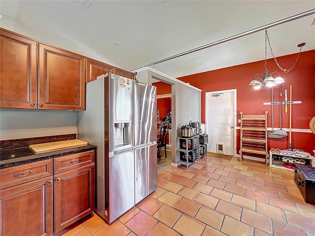 1044 Dees Dr, Oviedo, FL 32765 - kitchen with stainless steel fridge with ice dispenser, dark countertops, brown cabinets, and light tile patterned floors