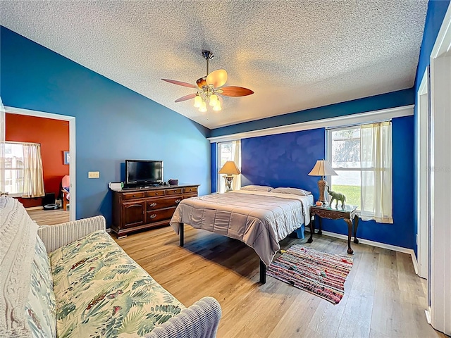 1044 Dees Dr, Oviedo, FL 32765 - bedroom with lofted ceiling, a textured ceiling, light wood finished floors, and a ceiling fan