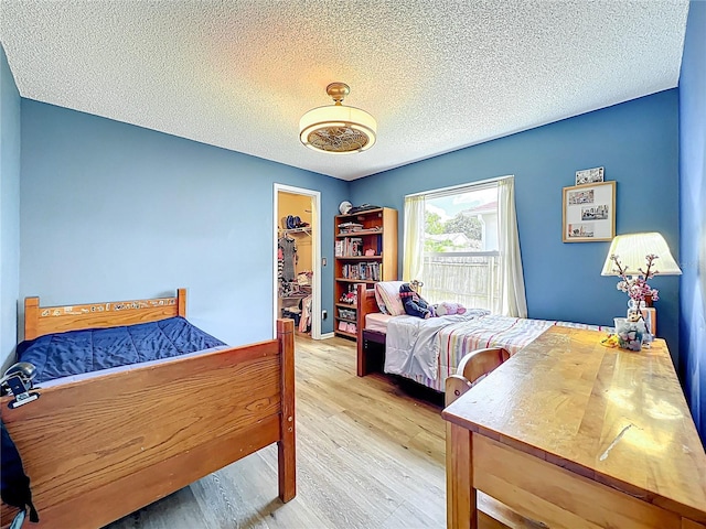 1044 Dees Dr, Oviedo, FL 32765 - bedroom featuring wood finished floors, a walk in closet, a textured ceiling, and a closet