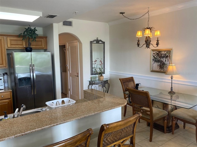 13415 Blue Heron Bch Unit 203, Orlando, FL 32821 - kitchen with stainless steel fridge with ice dispenser, arched walkways, light tile patterned flooring, crown molding, and pendant lighting