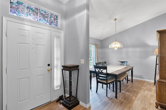1113 Canopy Oaks Dr, Minneola, FL 34715 - entryway featuring light wood finished floors, a chandelier, and lofted ceiling