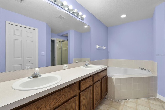 1113 Canopy Oaks Dr, Minneola, FL 34715 - bathroom with double vanity, a garden tub, a stall shower, and tile patterned floors
