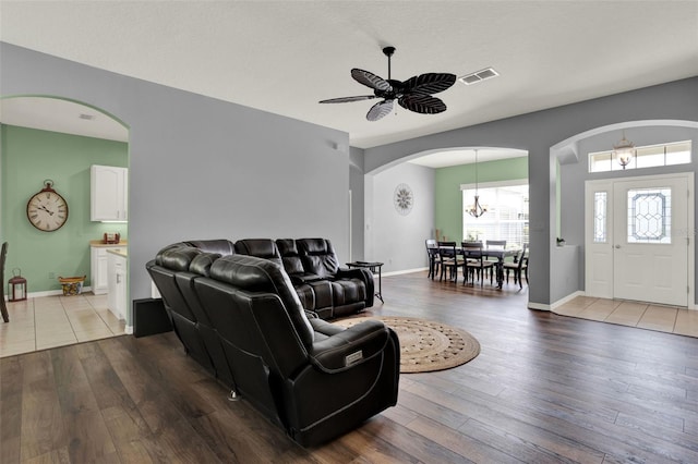 25105 Laurel Valley Rd, Leesburg, FL 34748 - living area featuring arched walkways, hardwood / wood-style floors, a chandelier, and a ceiling fan